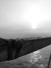 A professional inspector carefully examining a wooden deck railing under bright Virginia Beach sunlight.