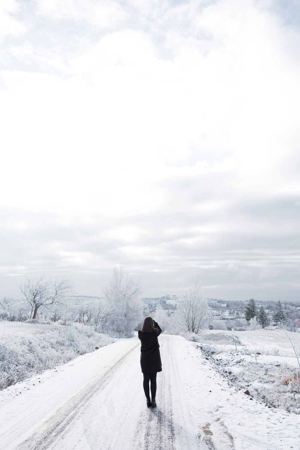 person in black jacket standing on snow covered ground during daytime