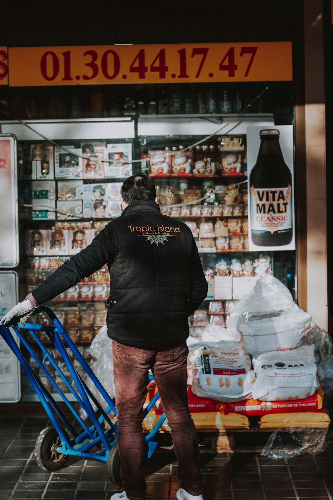man in black hoodie standing in front of grocery cart