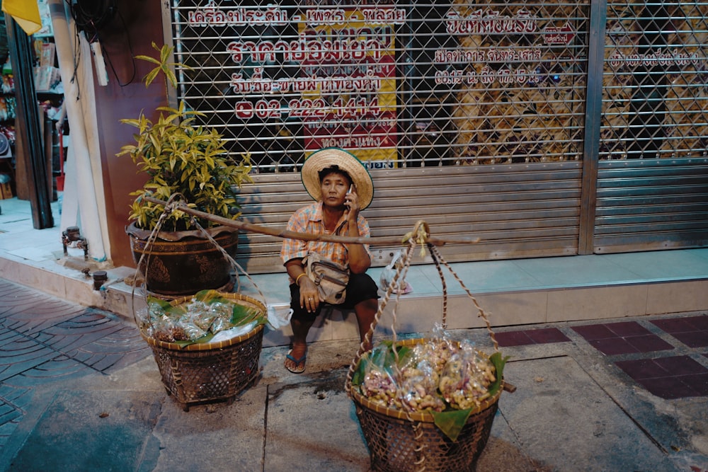 man in brown jacket sitting on brown concrete floor