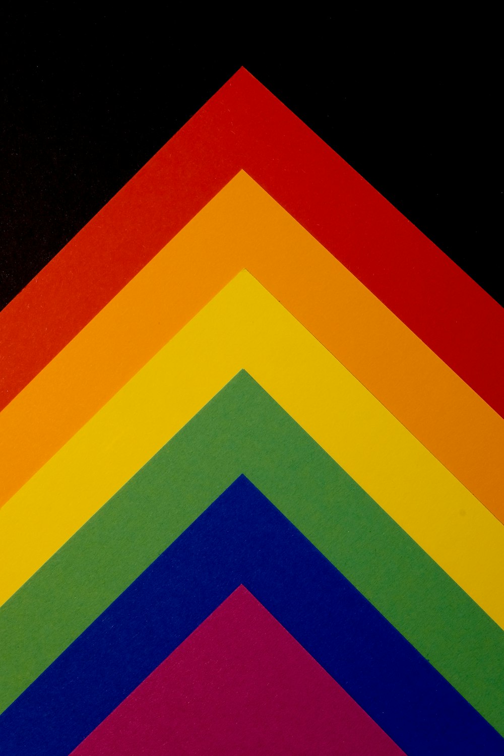 um close up de um triângulo multicolorido em um fundo preto