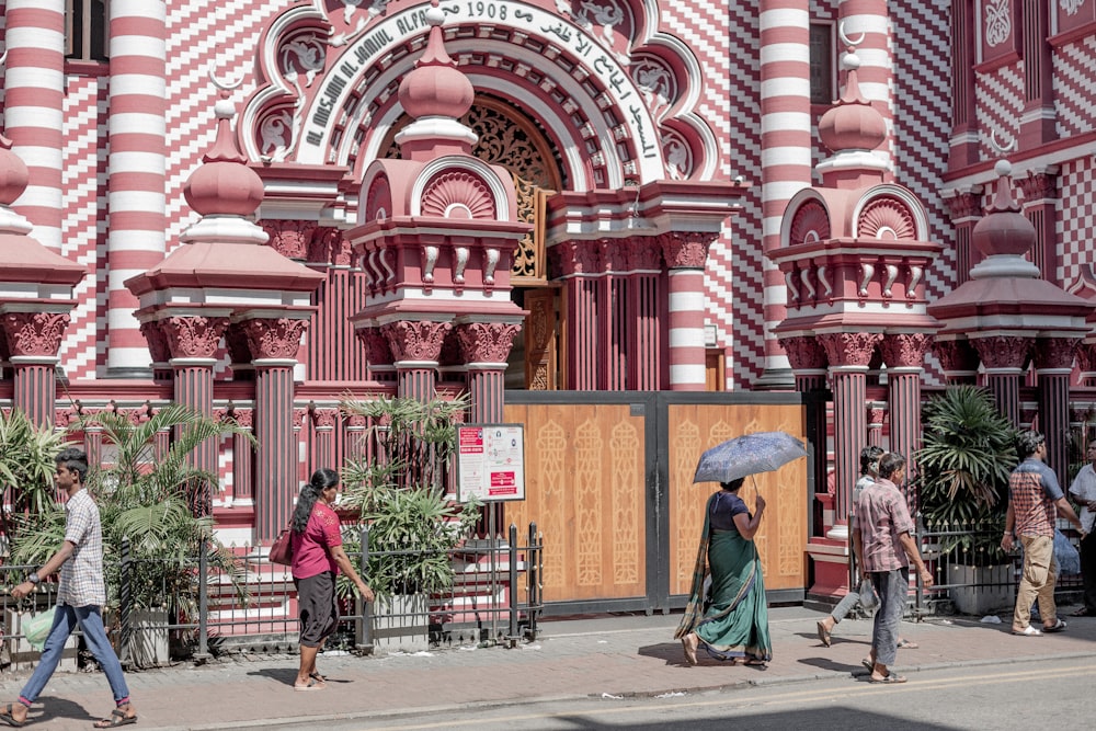 a group of people walking down a street with an umbrella