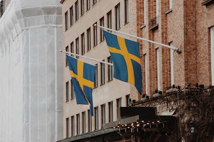 a couple of flags hanging from the side of a building