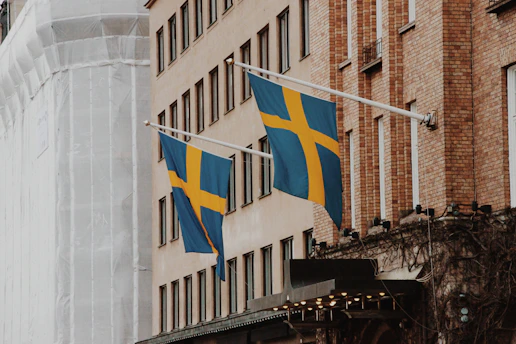 a couple of flags hanging from the side of a building