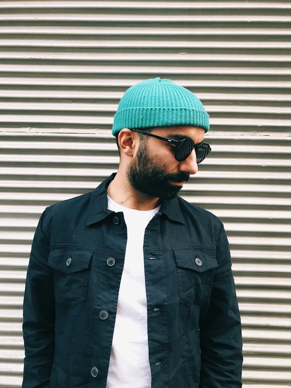 a man with a beard wearing a green hat