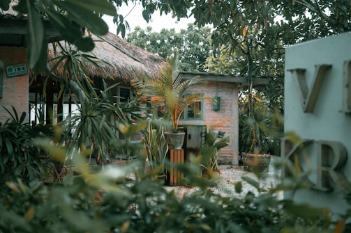 brown wooden house near green trees during daytime