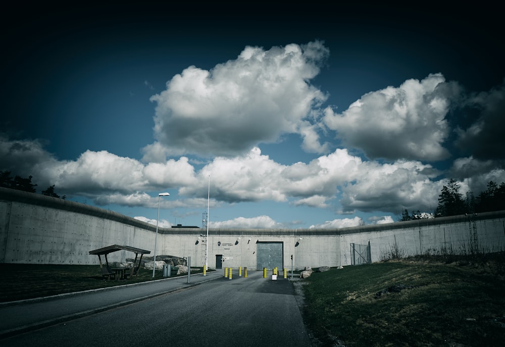 a large concrete building sitting next to a lush green field