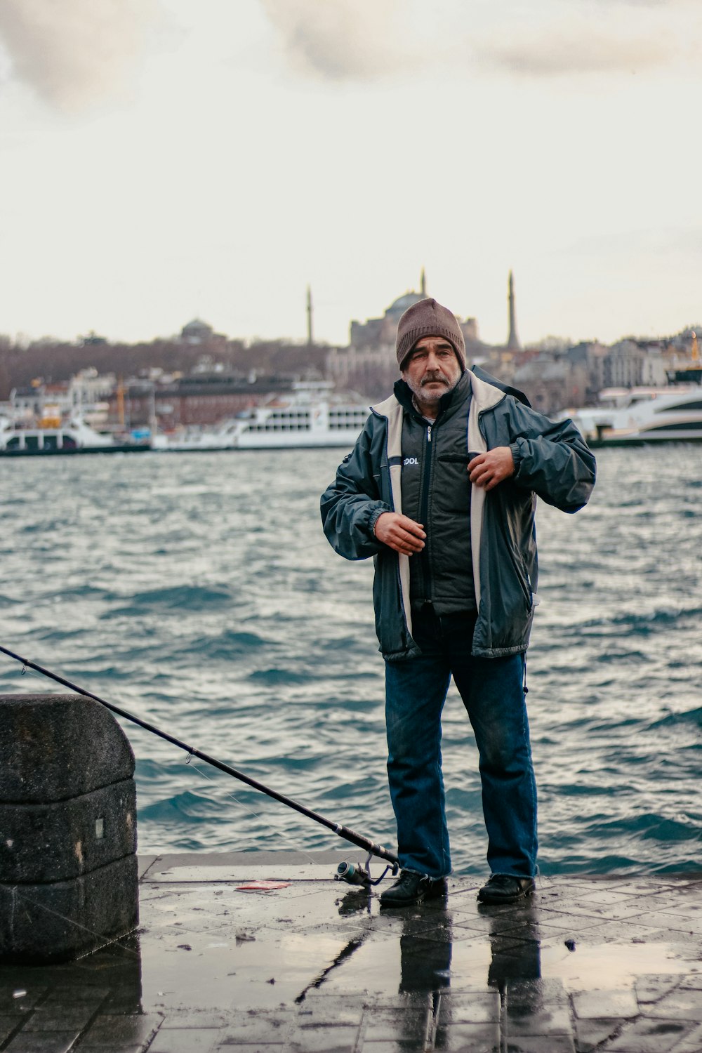 a man standing on a dock next to a body of water