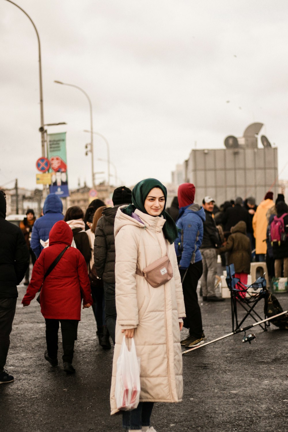 a woman standing in a parking lot with a lot of people