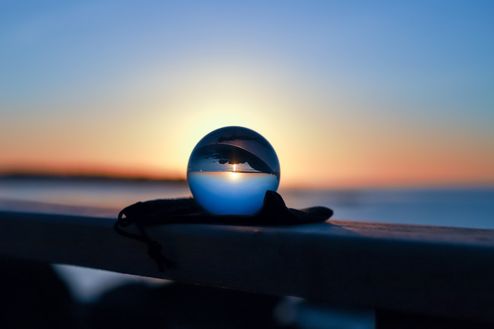 a blue ball sitting on top of a wooden rail