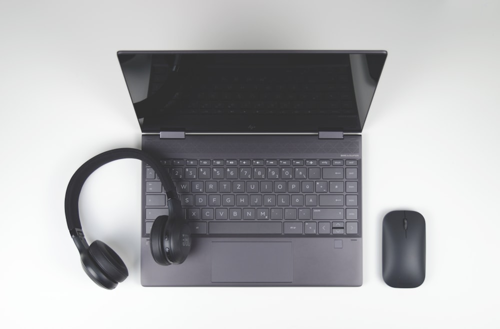 a laptop computer with headphones and a mouse