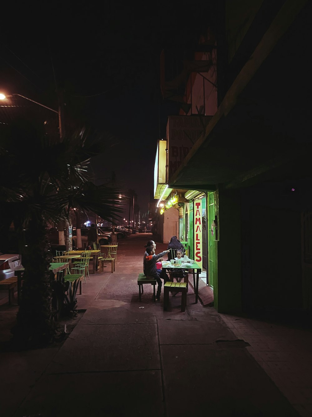 a person sitting at a table in the dark