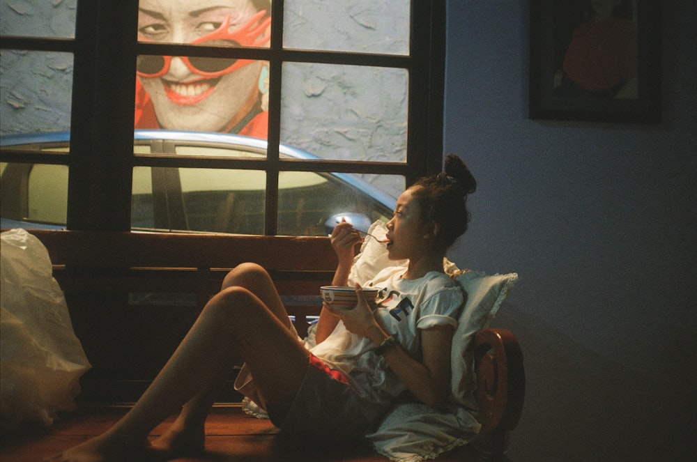 a woman sitting on a chair drinking a glass of wine