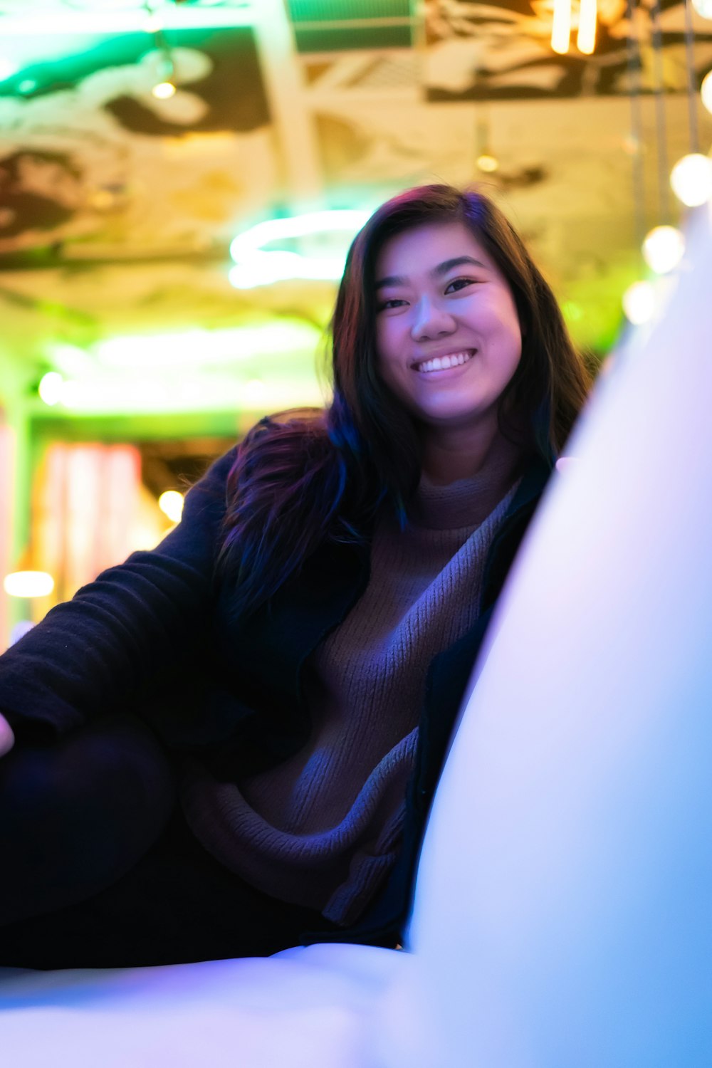 a woman sitting on a couch smiling at the camera