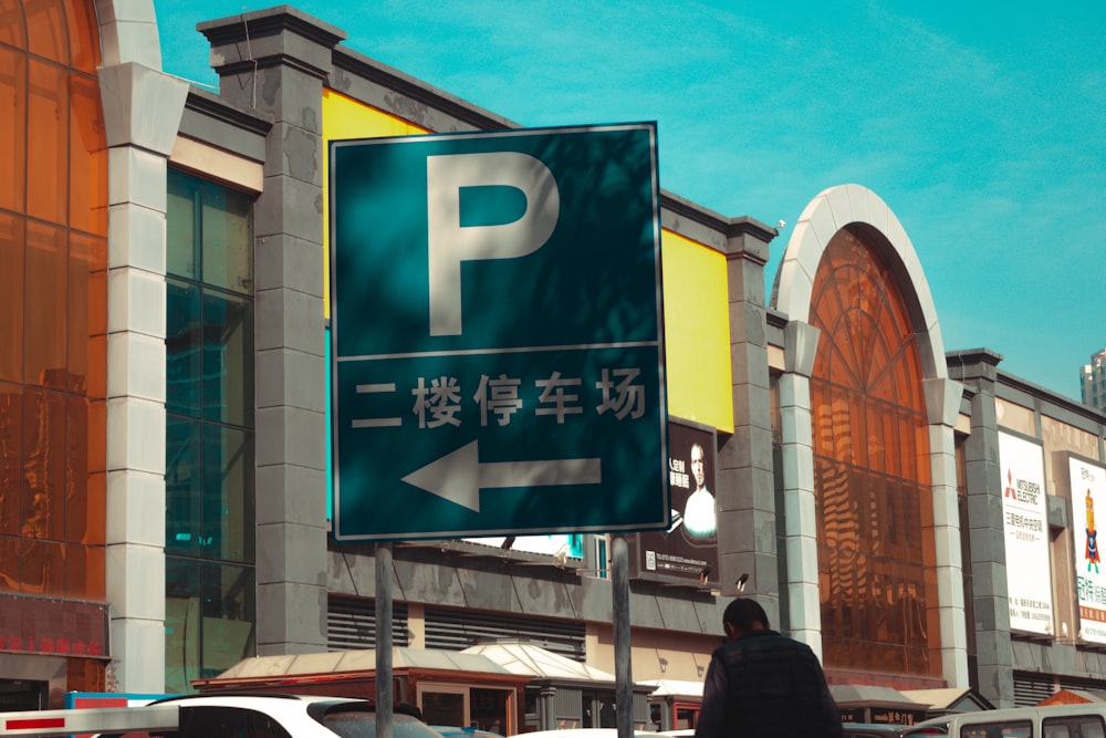 a man walking down a street next to a parking sign