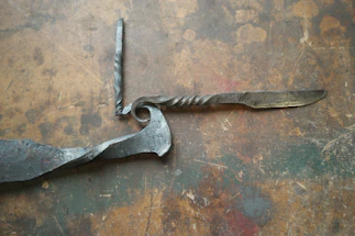 Close-up of a hand-forged Damascus hunting knife resting on rustic wood.