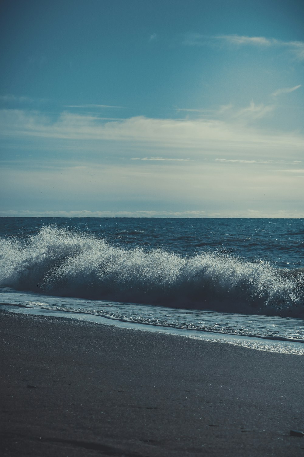 a person walking on the beach with a surfboard