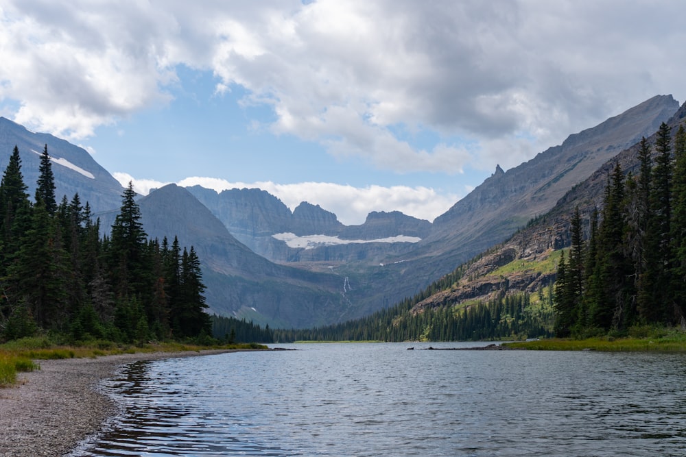 Un lago circondato da alberi e montagne sotto un cielo nuvoloso