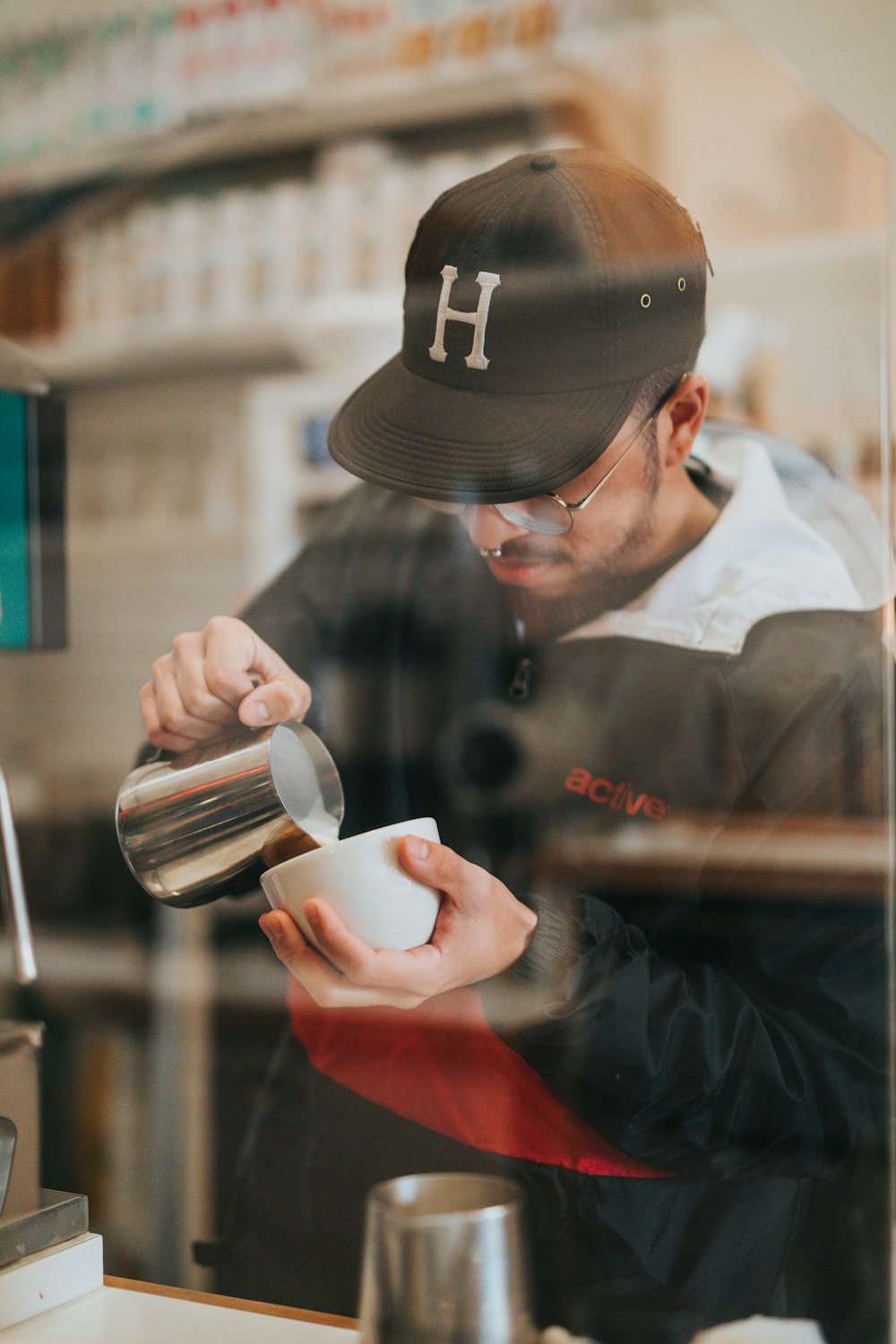 a man pouring a cup of coffee in a coffee shop