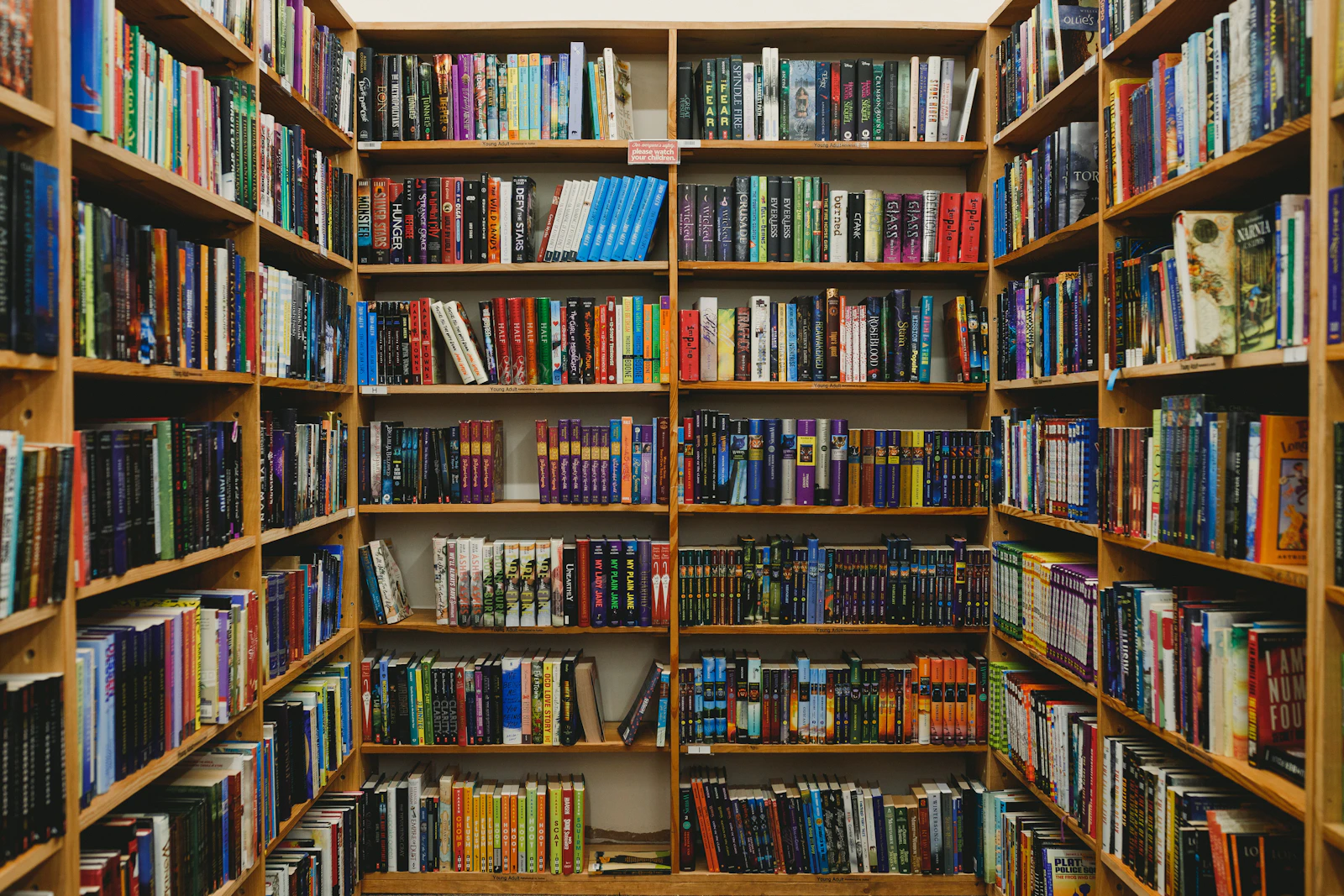 Wooden shelves filled with books from different collections