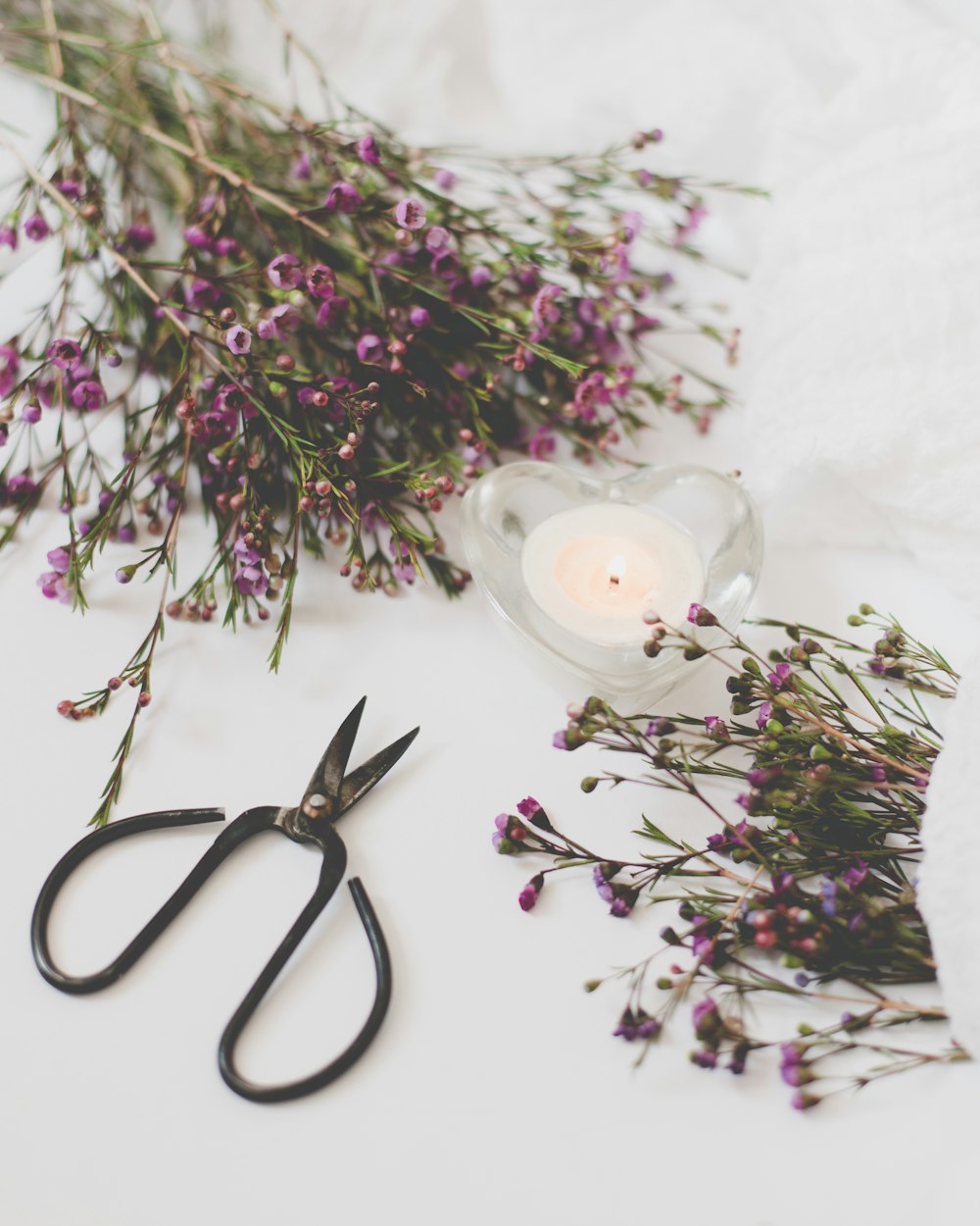 une paire de ciseaux assis à côté d’un bouquet de fleurs