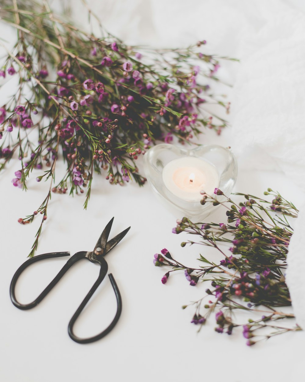 a pair of scissors sitting next to a bunch of flowers