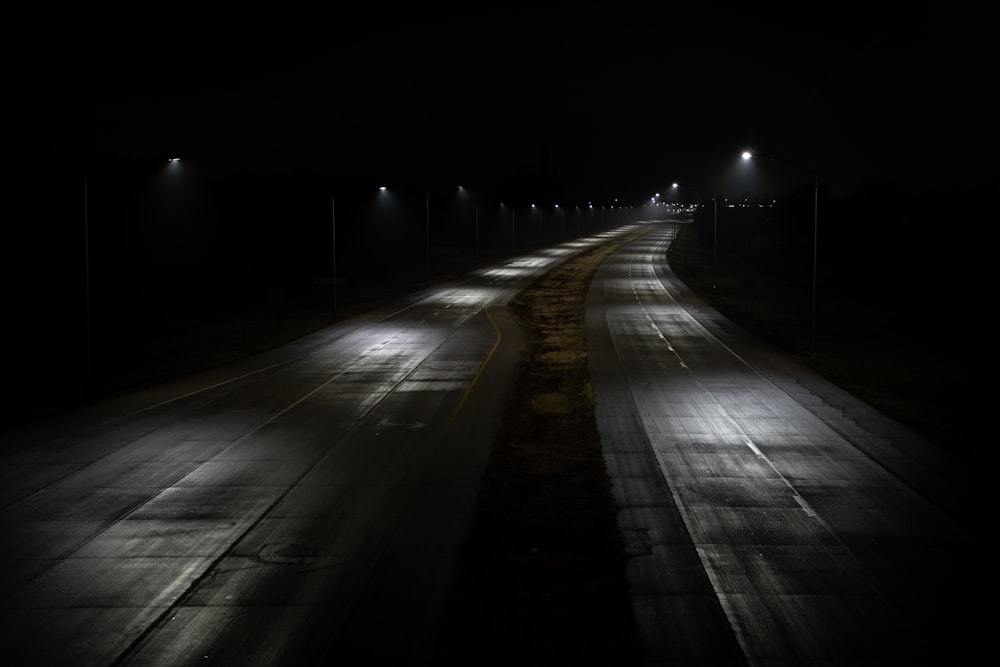 empty road with lights turned on during night time