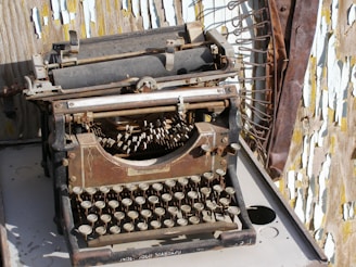 An antique typewriter surrounded by sheets of typed paper.