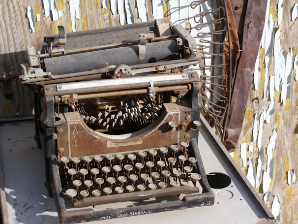 An antique typewriter surrounded by sheets of typed paper.