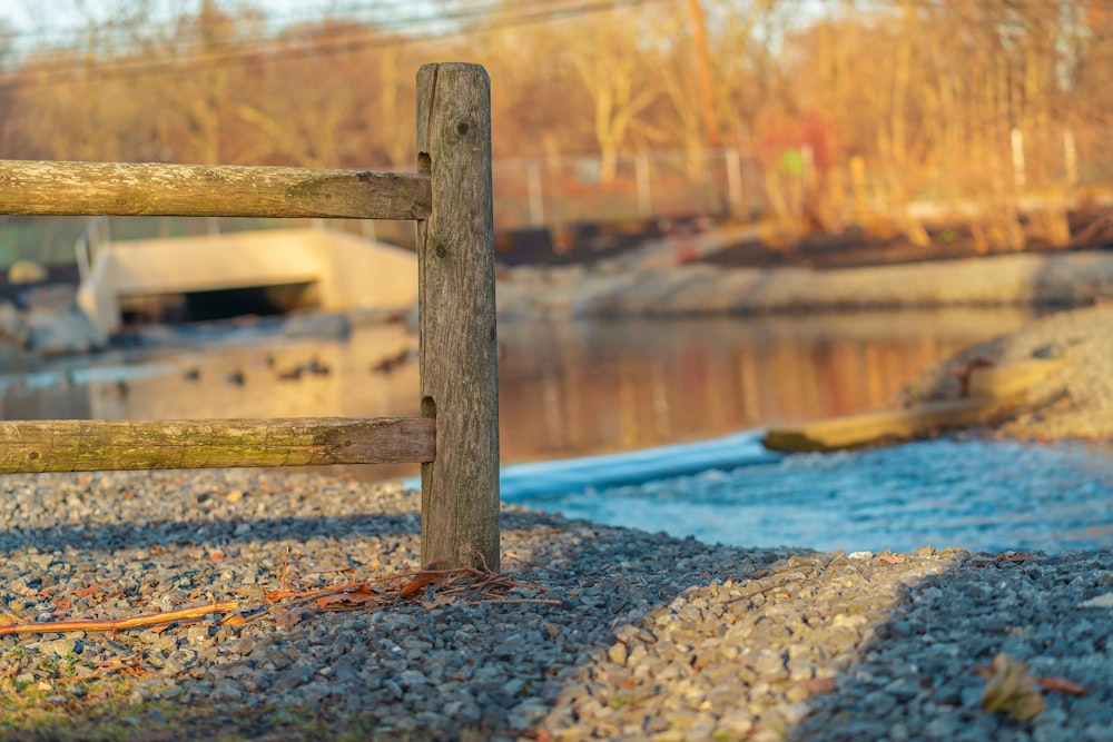 brown wooden fence near body of water during daytime