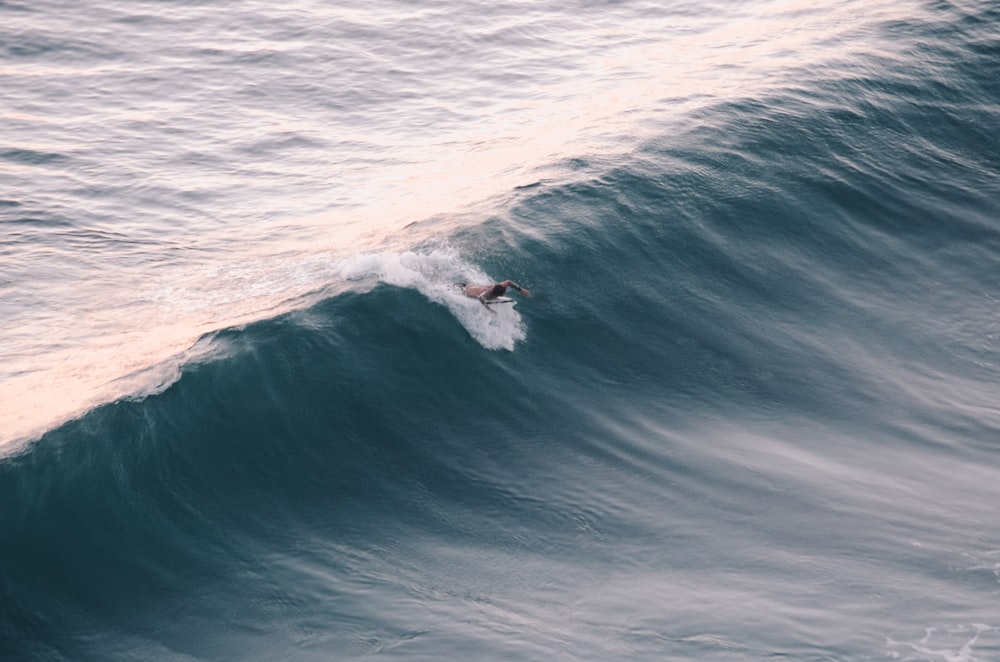 a man riding a wave on top of a surfboard