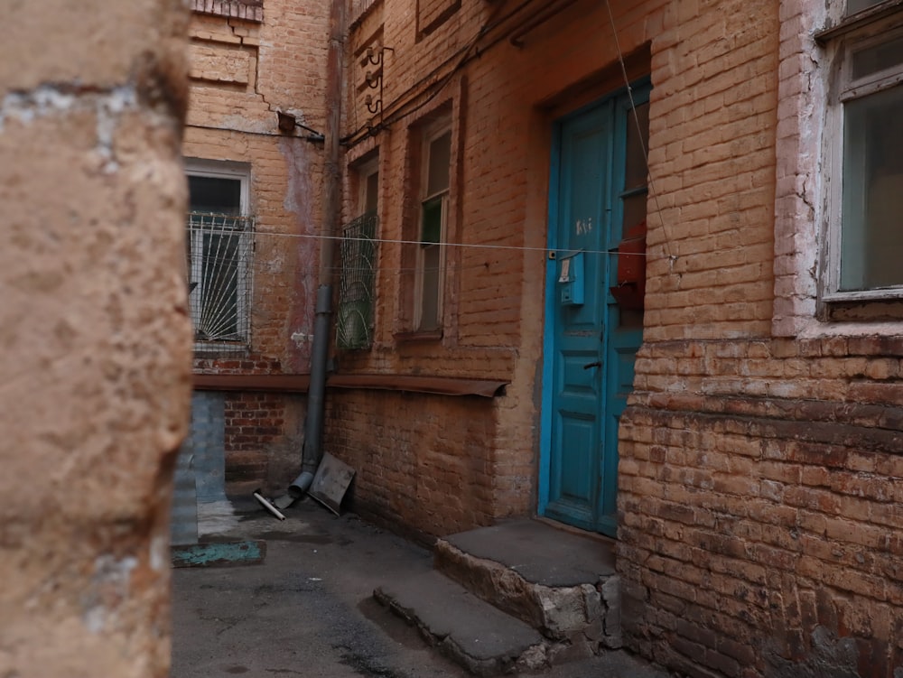 blue wooden door on brown brick building