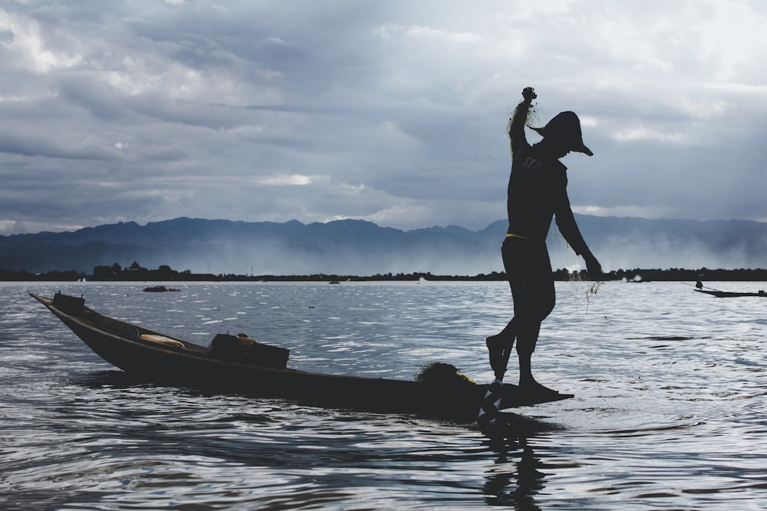 silhouette of man and woman on boat on water during daytime