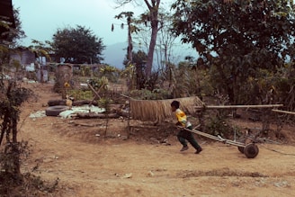 A lively pioneer games competition with kids laughing and cheering as they race with wooden handcarts.