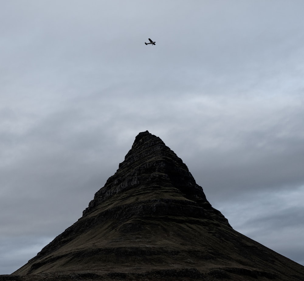 an airplane is flying over a mountain in the sky