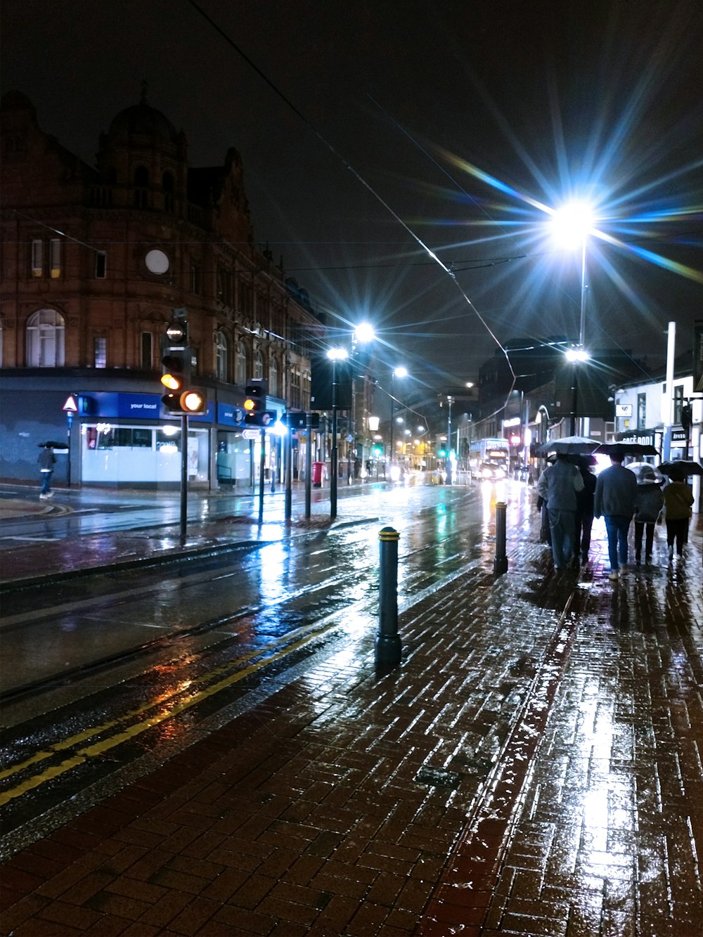 a group of people walking down a street at night