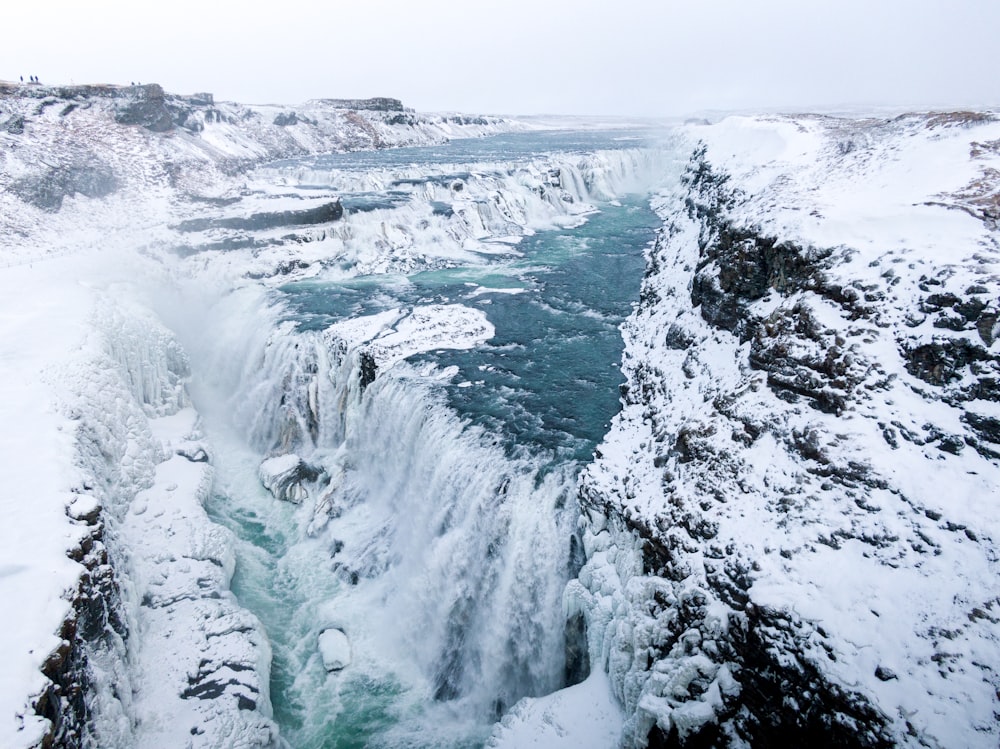 Une très haute cascade au milieu d’un champ enneigé