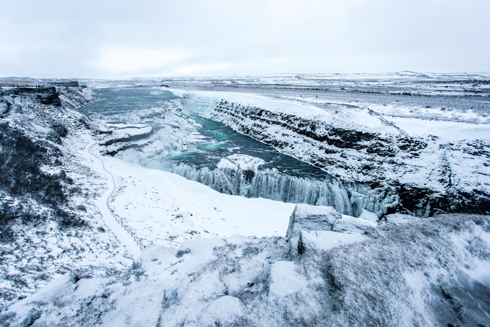 a frozen waterfall in the middle of a snowy landscape