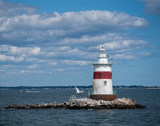 a red and white lighthouse sitting on top of a pier