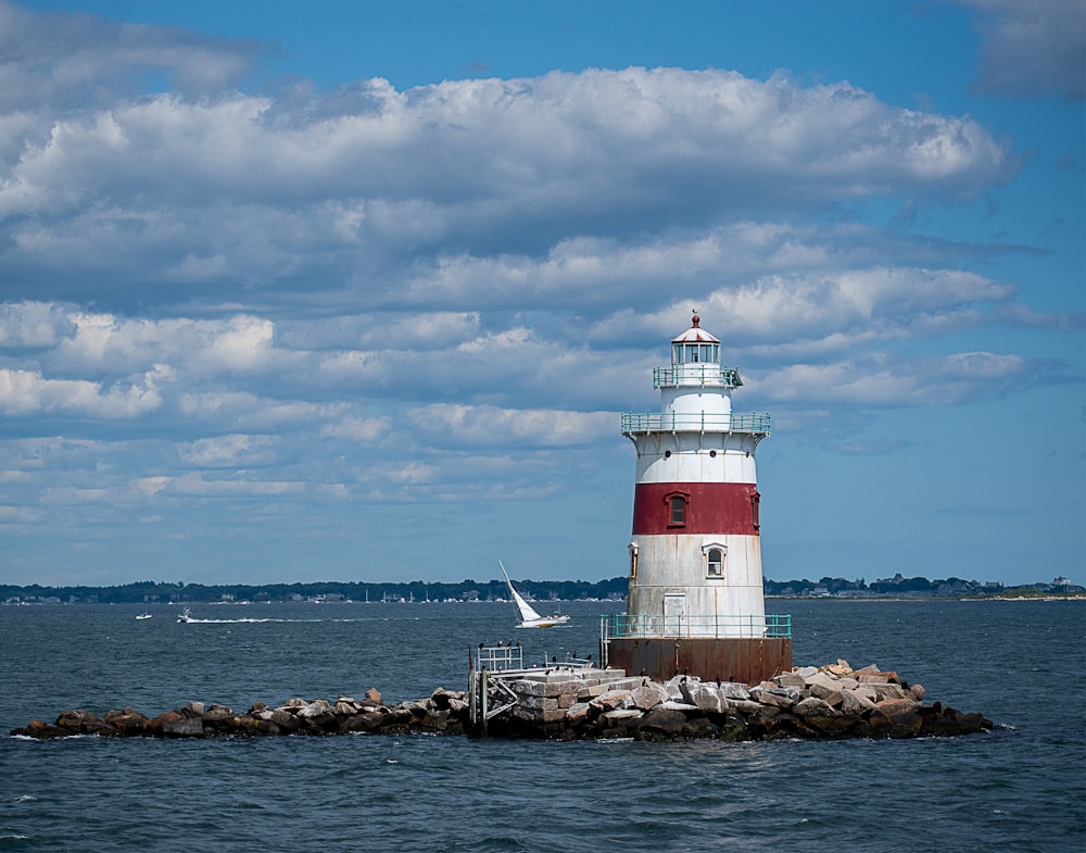 a red and white lighthouse sitting on top of a pier