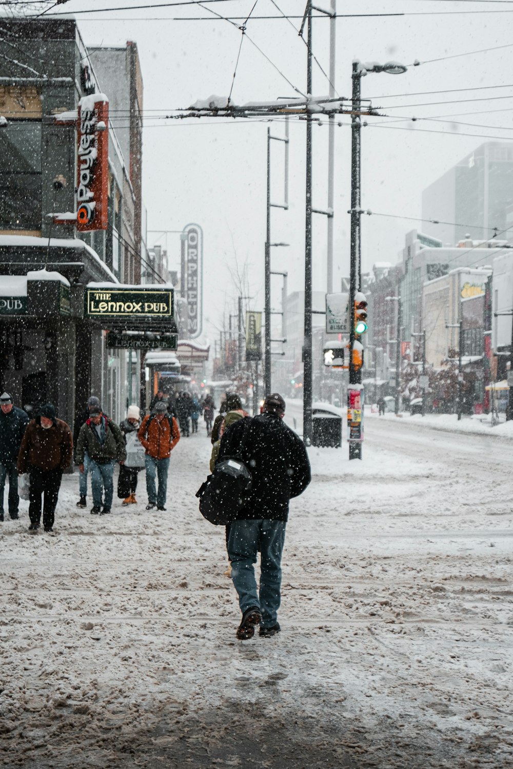 a group of people walking down a snow covered street