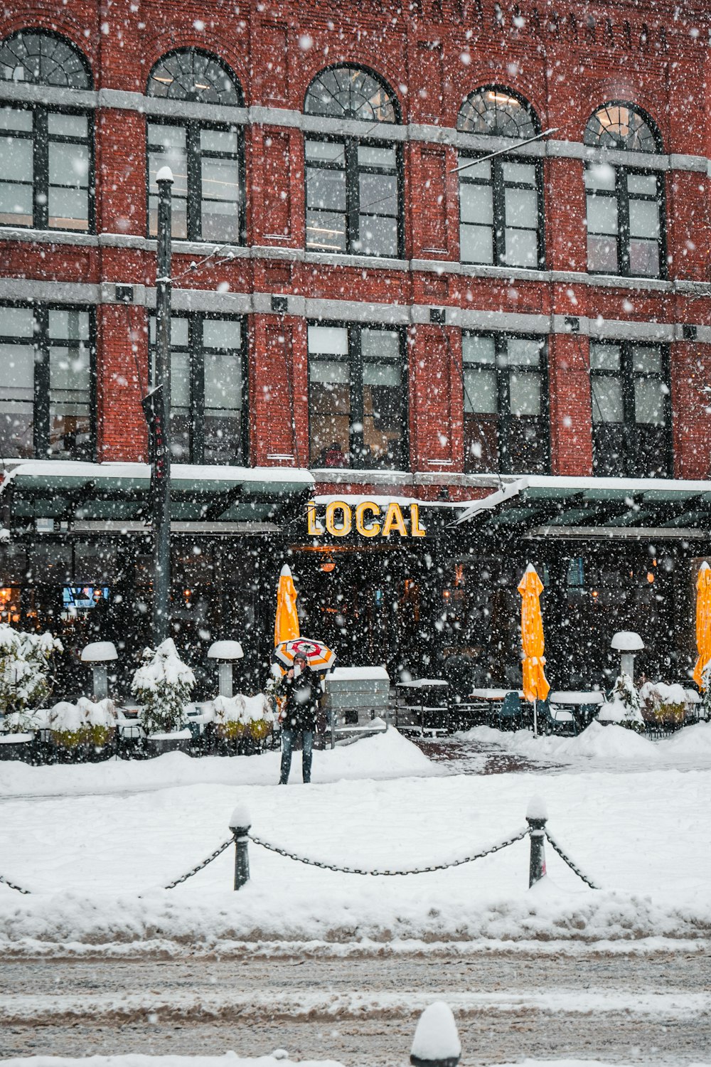 a person standing in the snow in front of a building