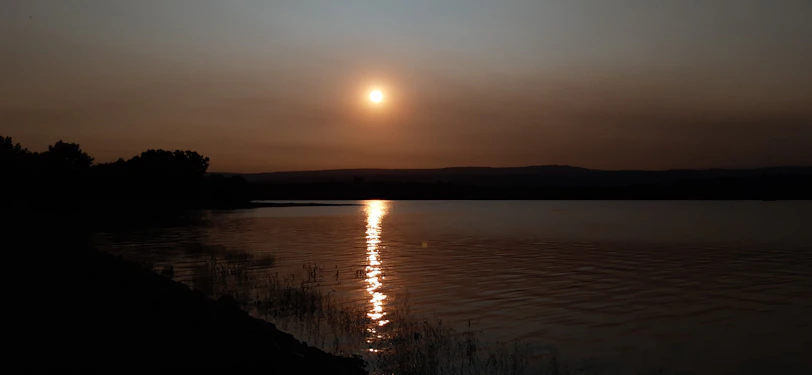 A peaceful sunset over calm waters symbolizing tranquility.