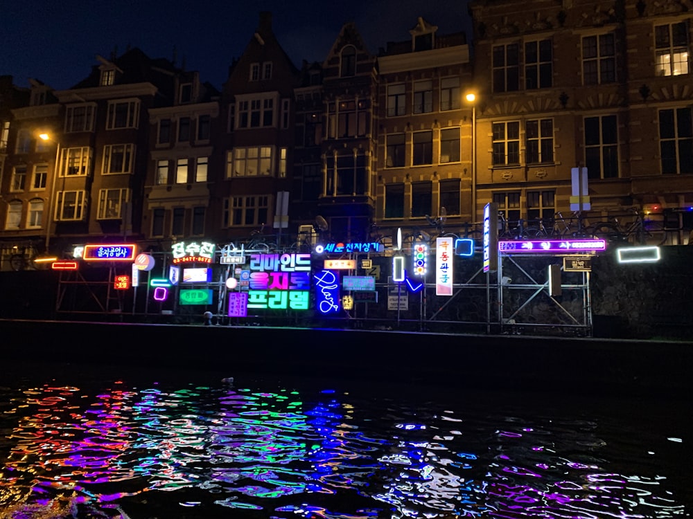 specchio d'acqua vicino a un edificio in cemento marrone durante la notte