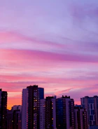 An elegant city skyline at dusk with subtle purple and gold hues.