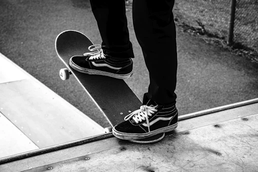 person in black pants wearing black and white sneakers