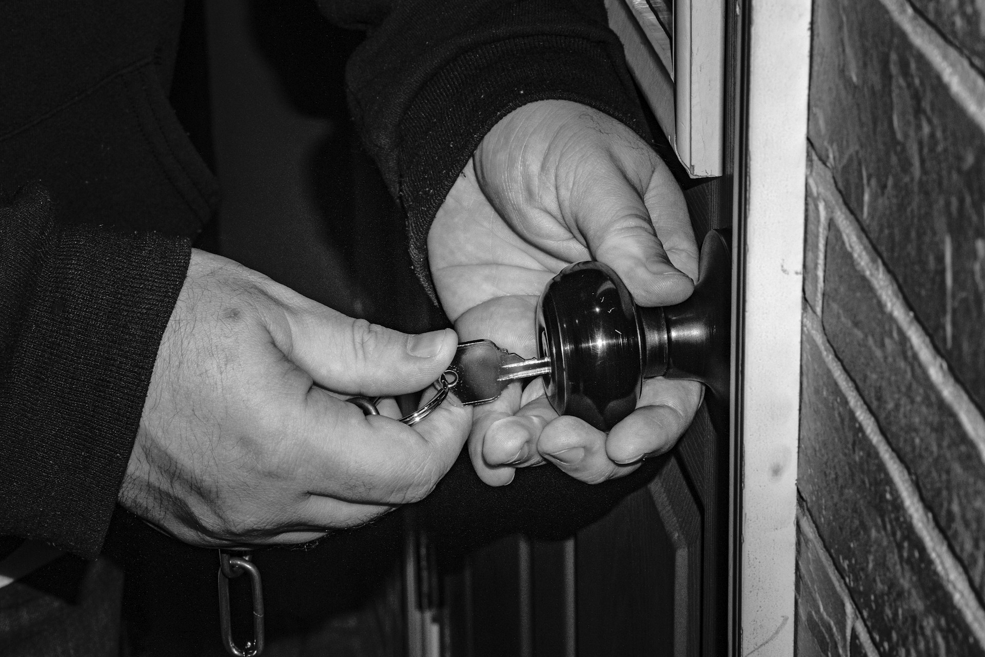 person holding black steel door knob