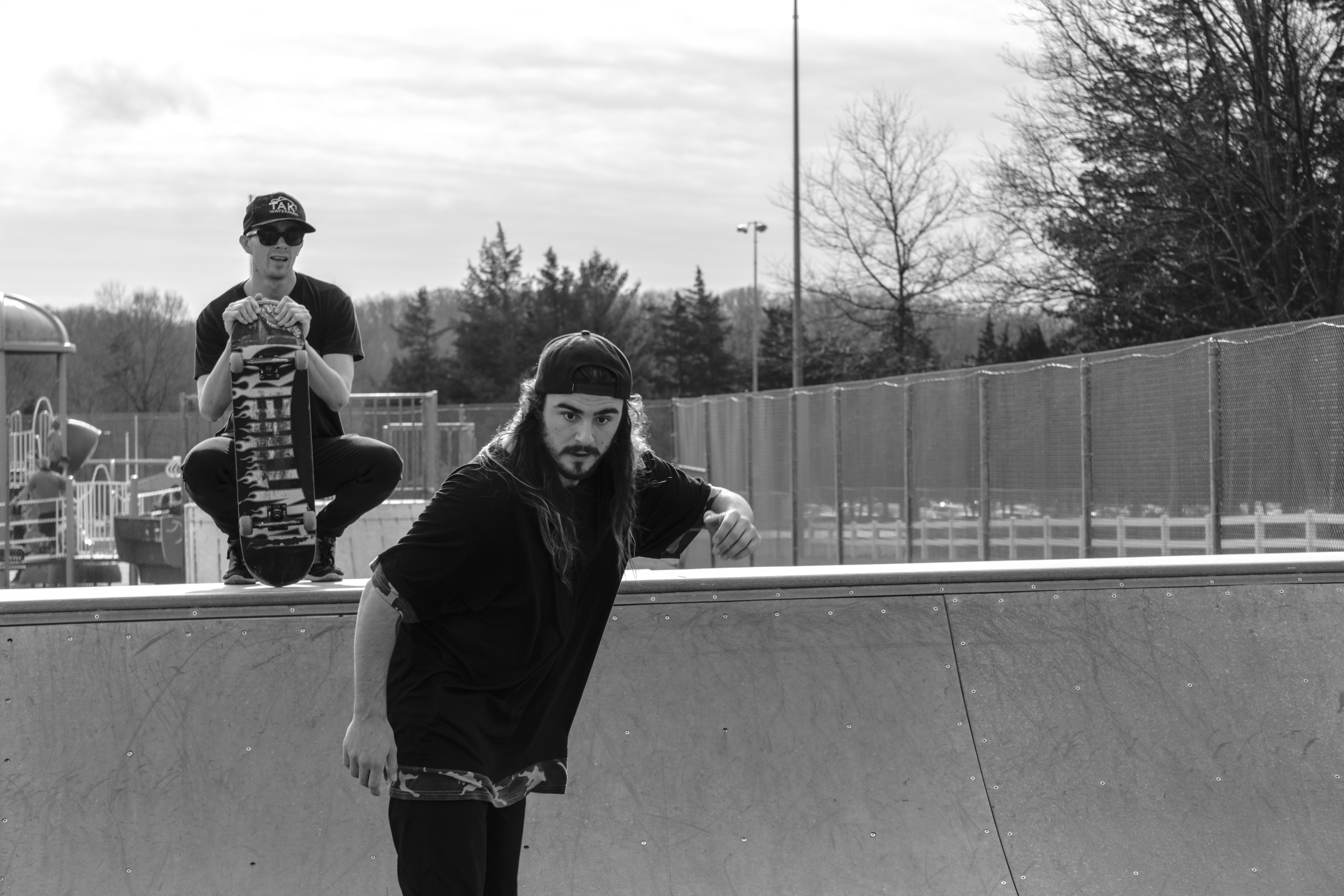 grayscale photo of woman in black long sleeve shirt standing beside man in black jacket new jersey teams background