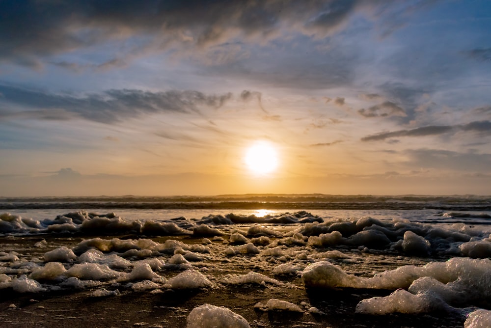 gray rocks on sea shore during sunset