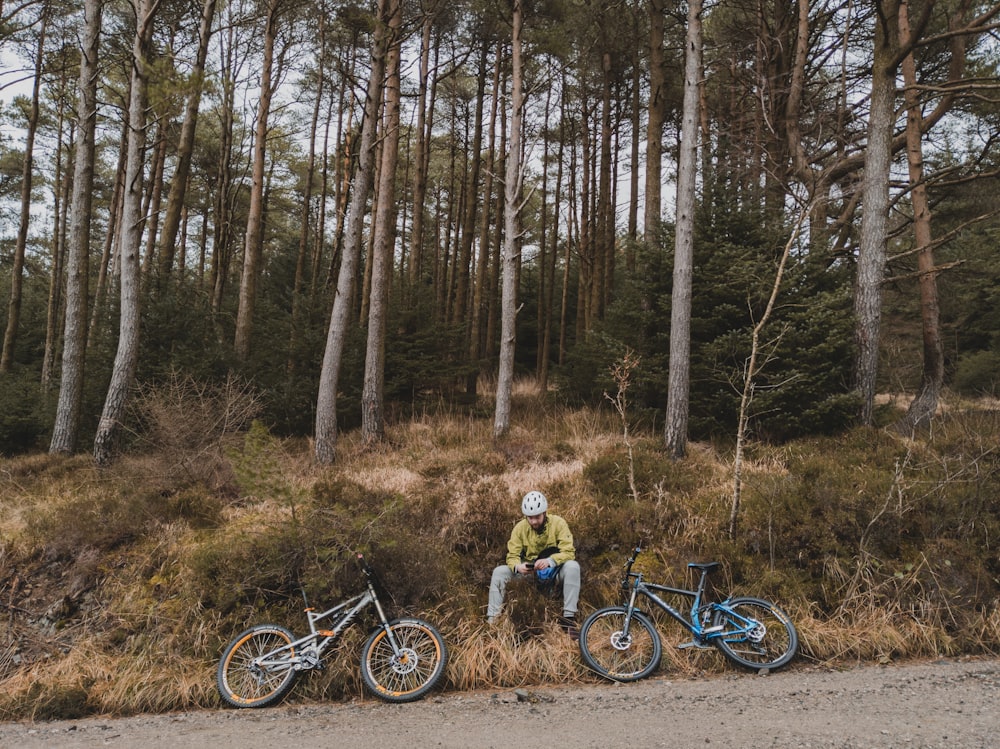 man in yellow jacket riding bicycle on forest during daytime